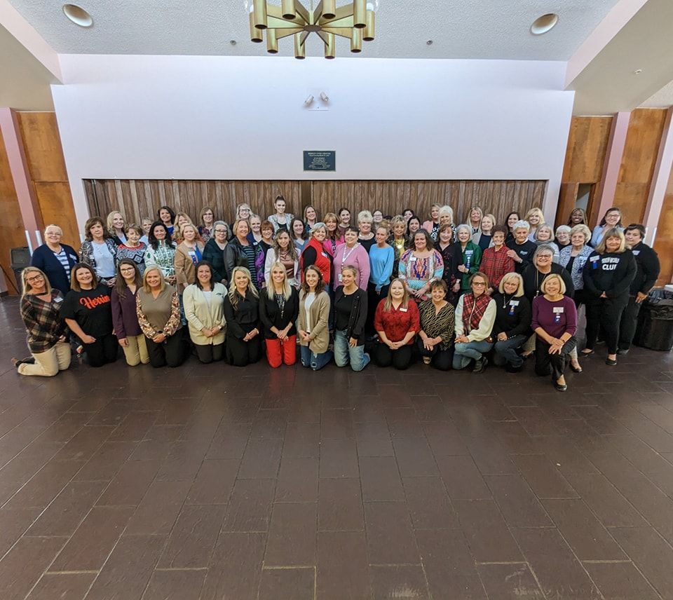 A large group of people are posing for a picture in a room