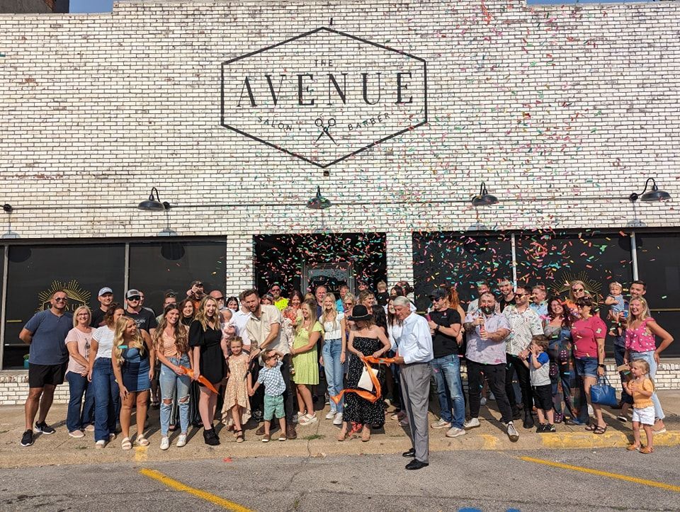 A large group of people are standing in front of a brick building.