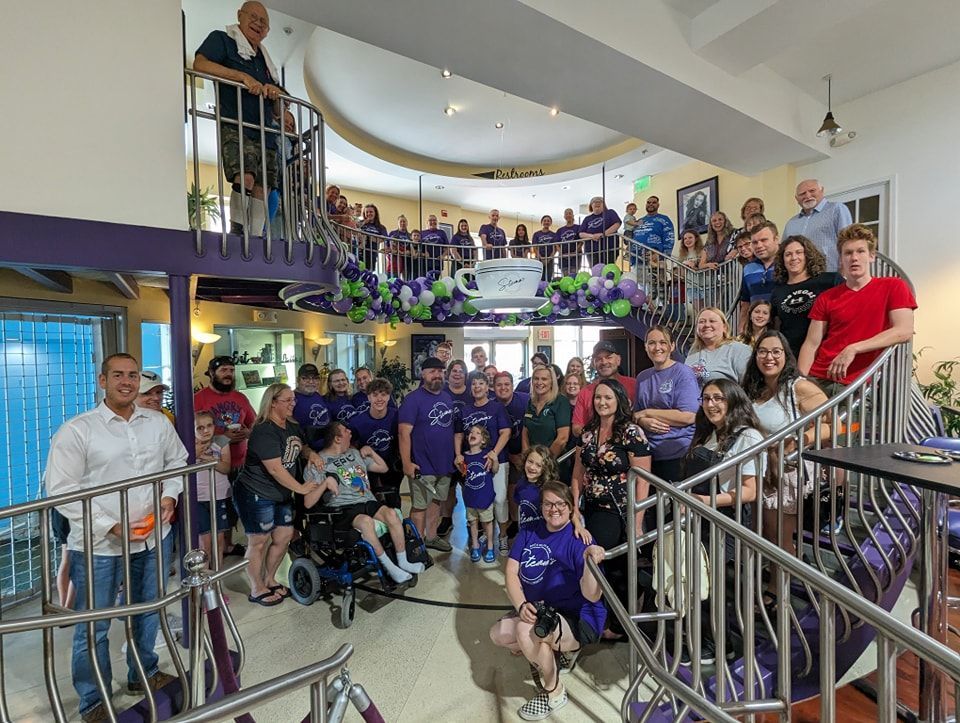 A large group of people are posing for a picture in a room.