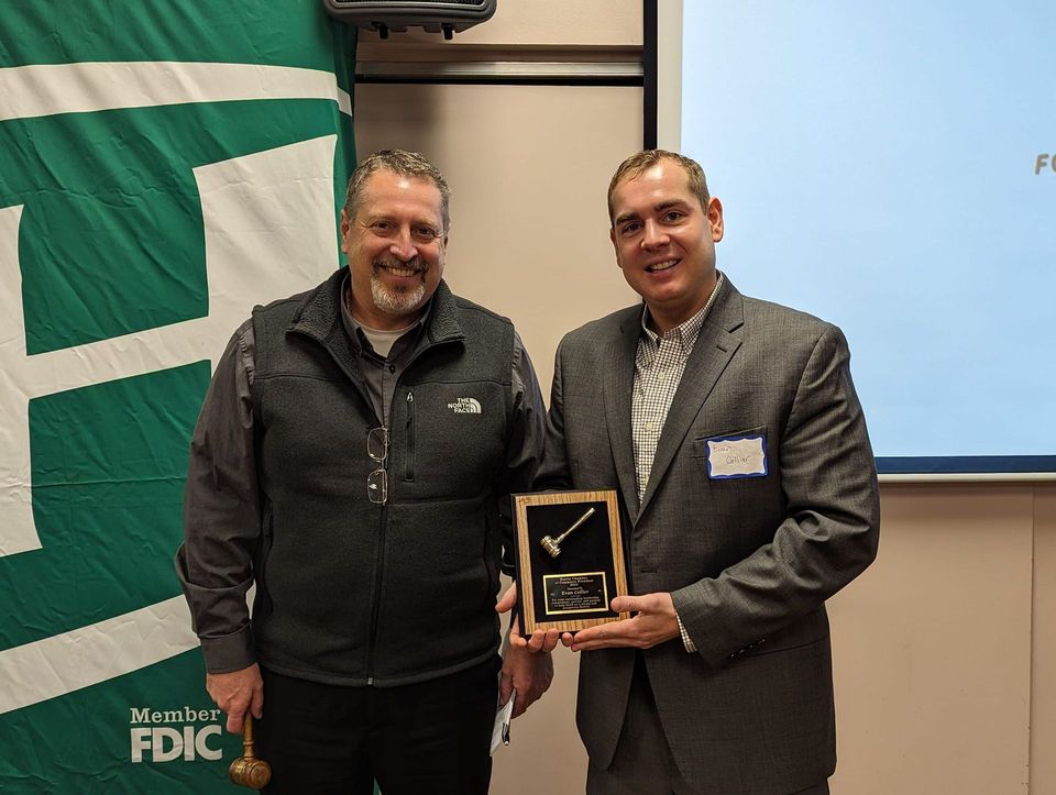 Two men are standing next to each other holding a plaque.