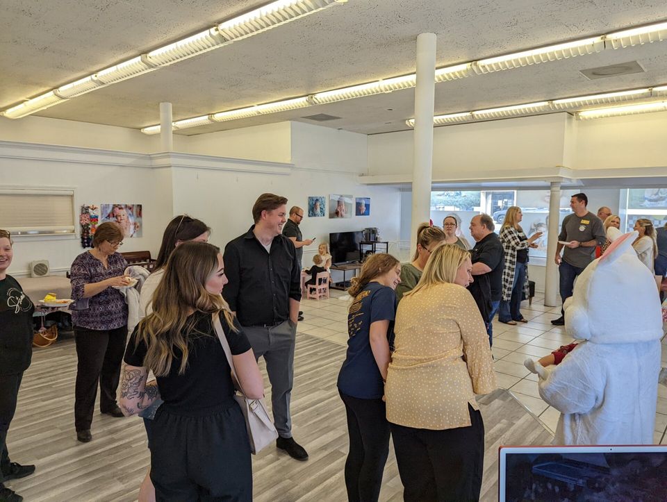 A group of people are standing in a room with a bunny mascot.