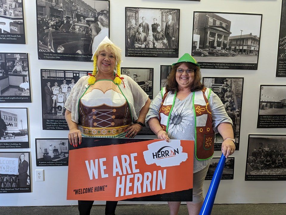 Two women holding a sign that says we are herrin