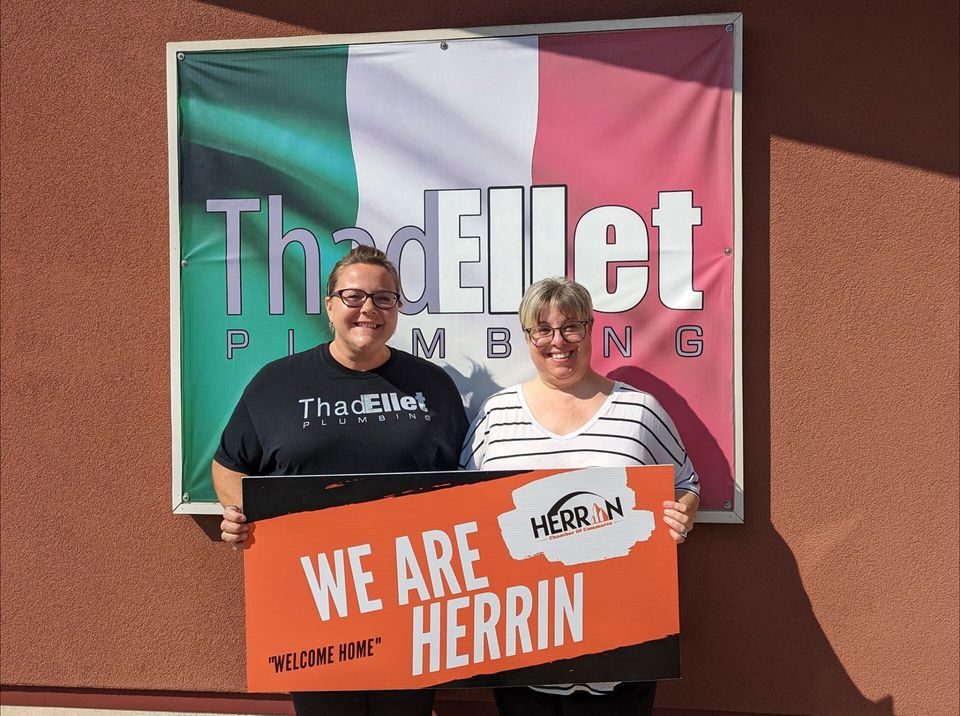 Two people holding a sign that says we are herrin