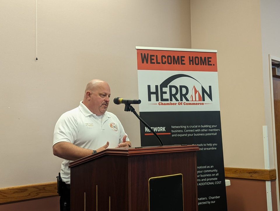 A man stands at a podium in front of a sign that says welcome home