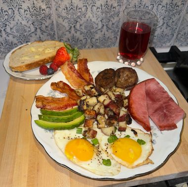 A plate of food with eggs bacon avocado and ham