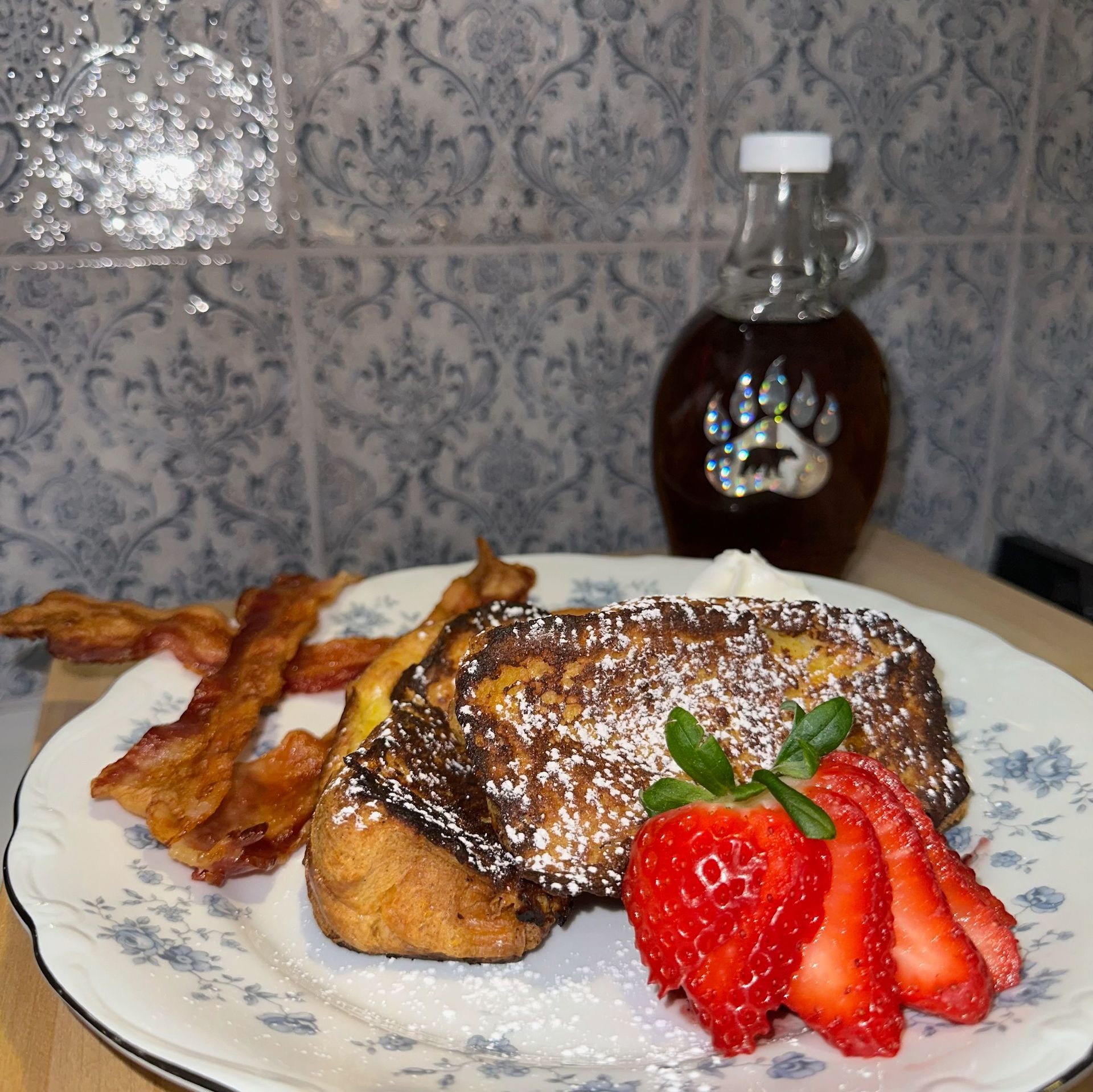 French toast with strawberries and bacon on a plate