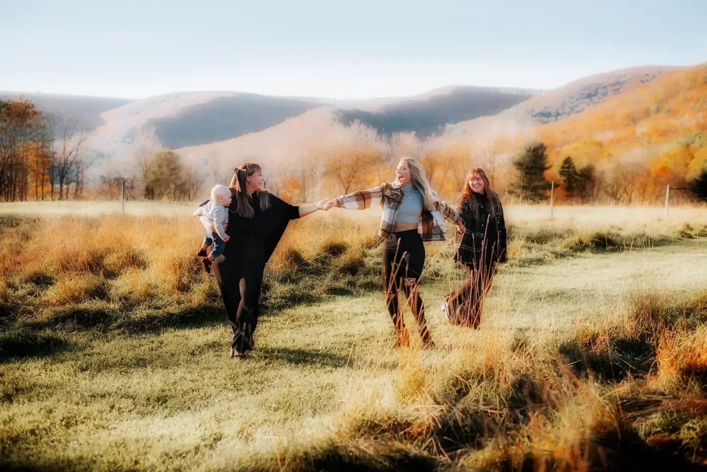 A group of people are walking through a field holding hands.