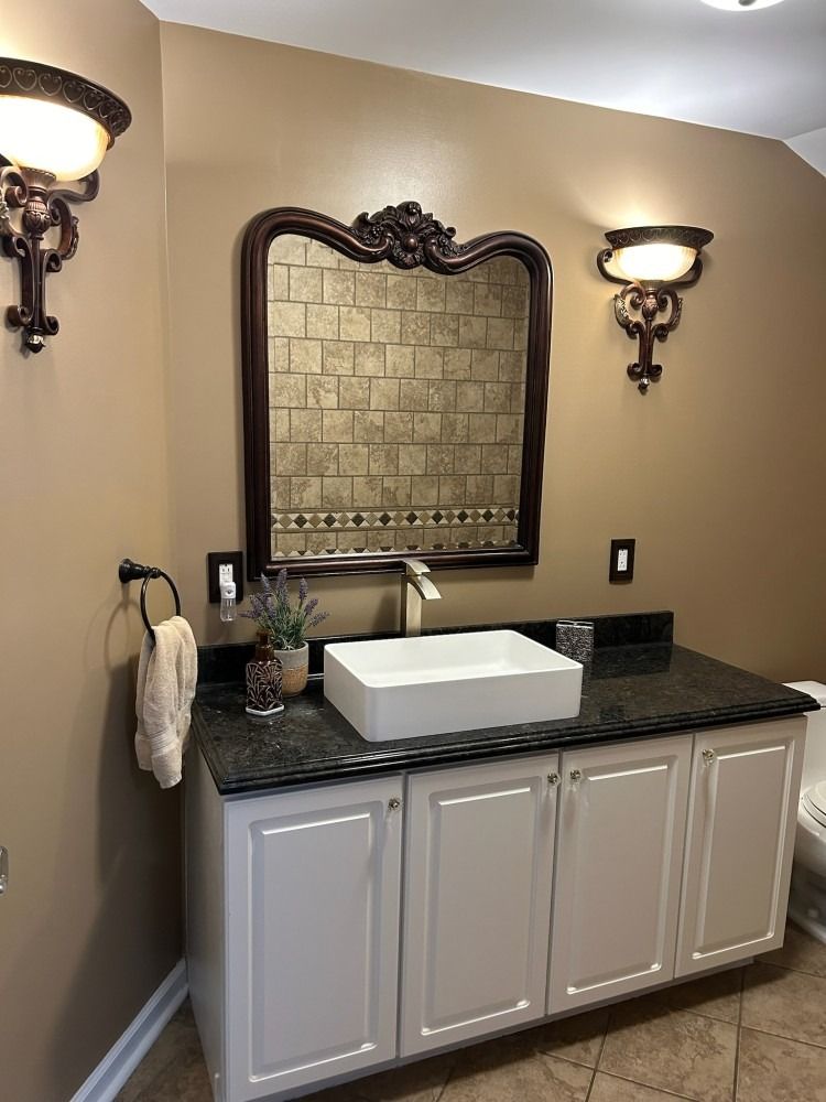 A bathroom with a sink , mirror , and toilet.