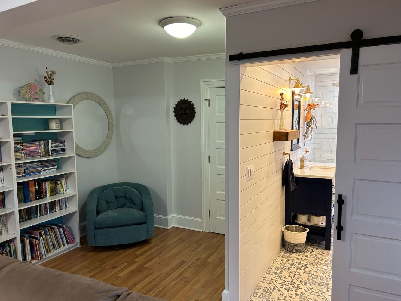 A living room with a sliding barn door leading to a bathroom.