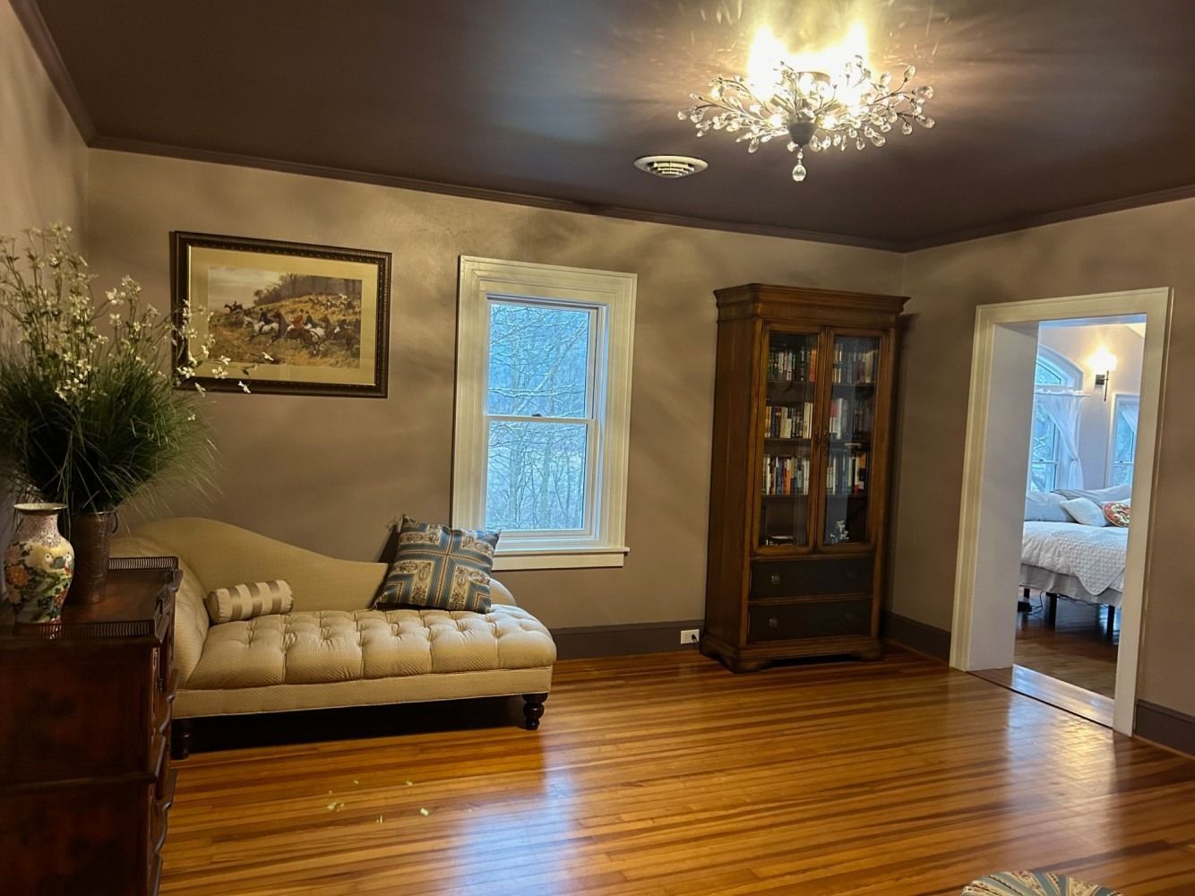 A living room with a couch , dresser , and bookcase.