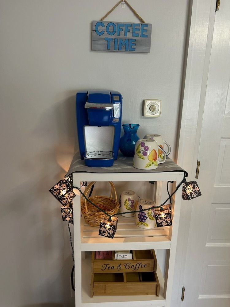 A coffee station with a coffee maker and a sign that says coffee time