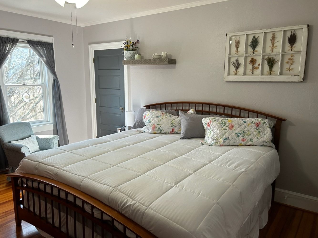 A bedroom with a king size bed and a chair.