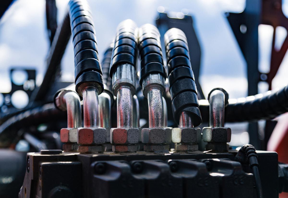 A close up of hydraulic hoses on a machine.