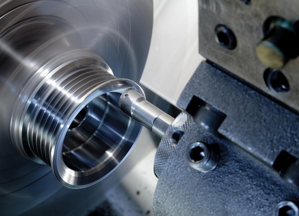 A machine is cutting a piece of metal on a lathe.