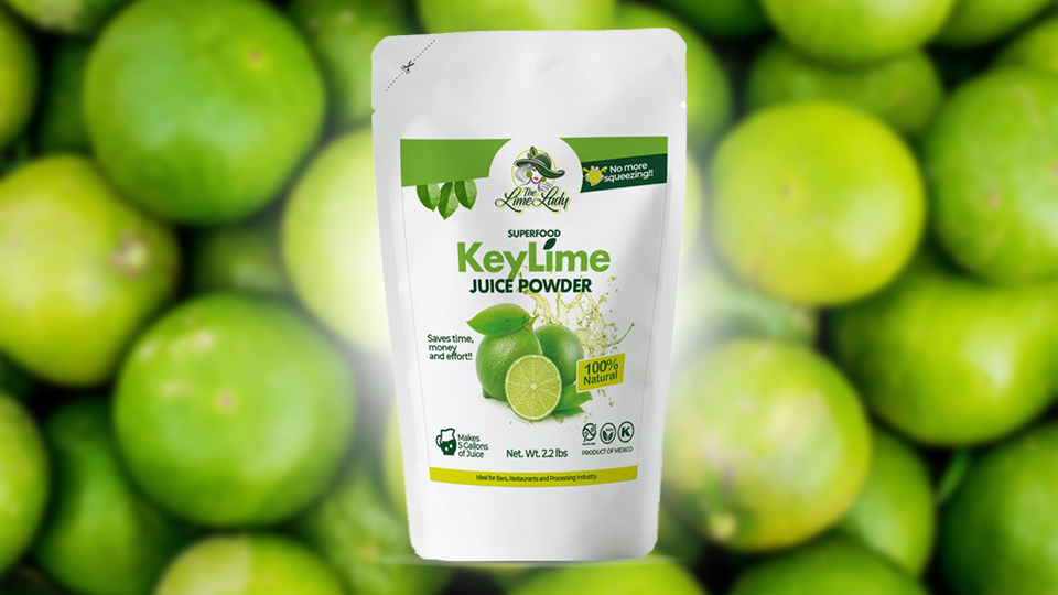 A bag of key lime juice powder is sitting on top of a pile of limes.