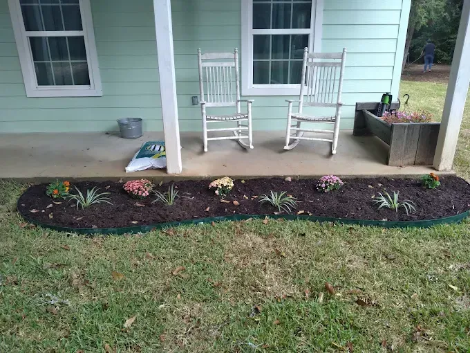 There are two rocking chairs on the porch of a house.