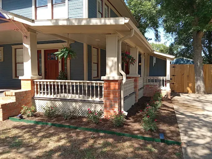 A house with a large porch and a wooden fence
