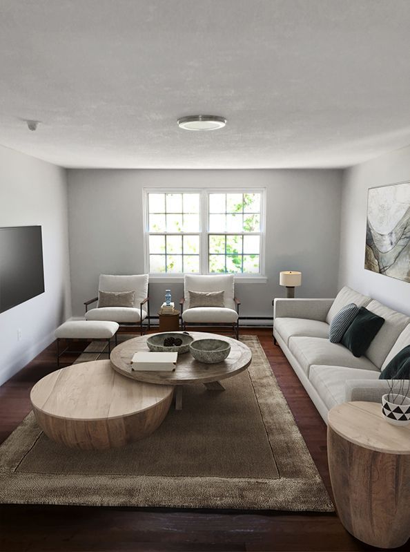 A living room with a couch , chairs , coffee tables and a flat screen tv