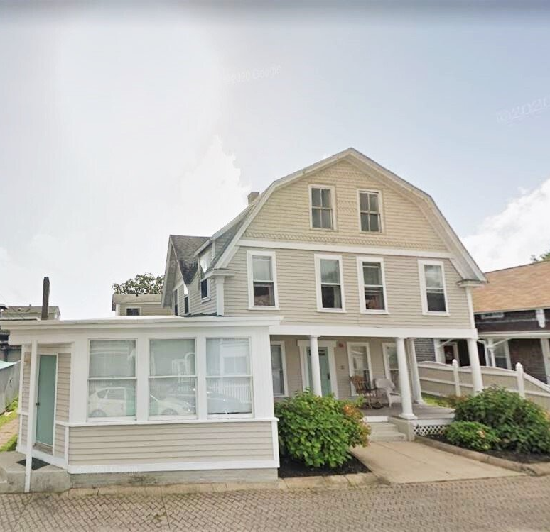 A large house with a large porch and many windows