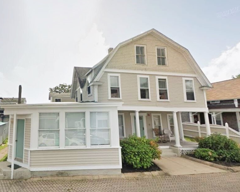A large house with a large porch and many windows