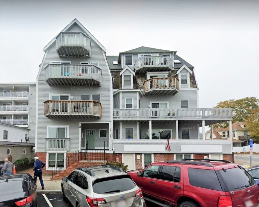 A large building with a lot of cars parked in front of it