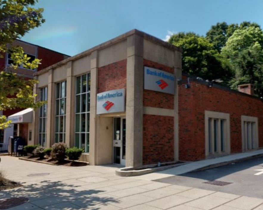 A bank of america building is on the corner of a street