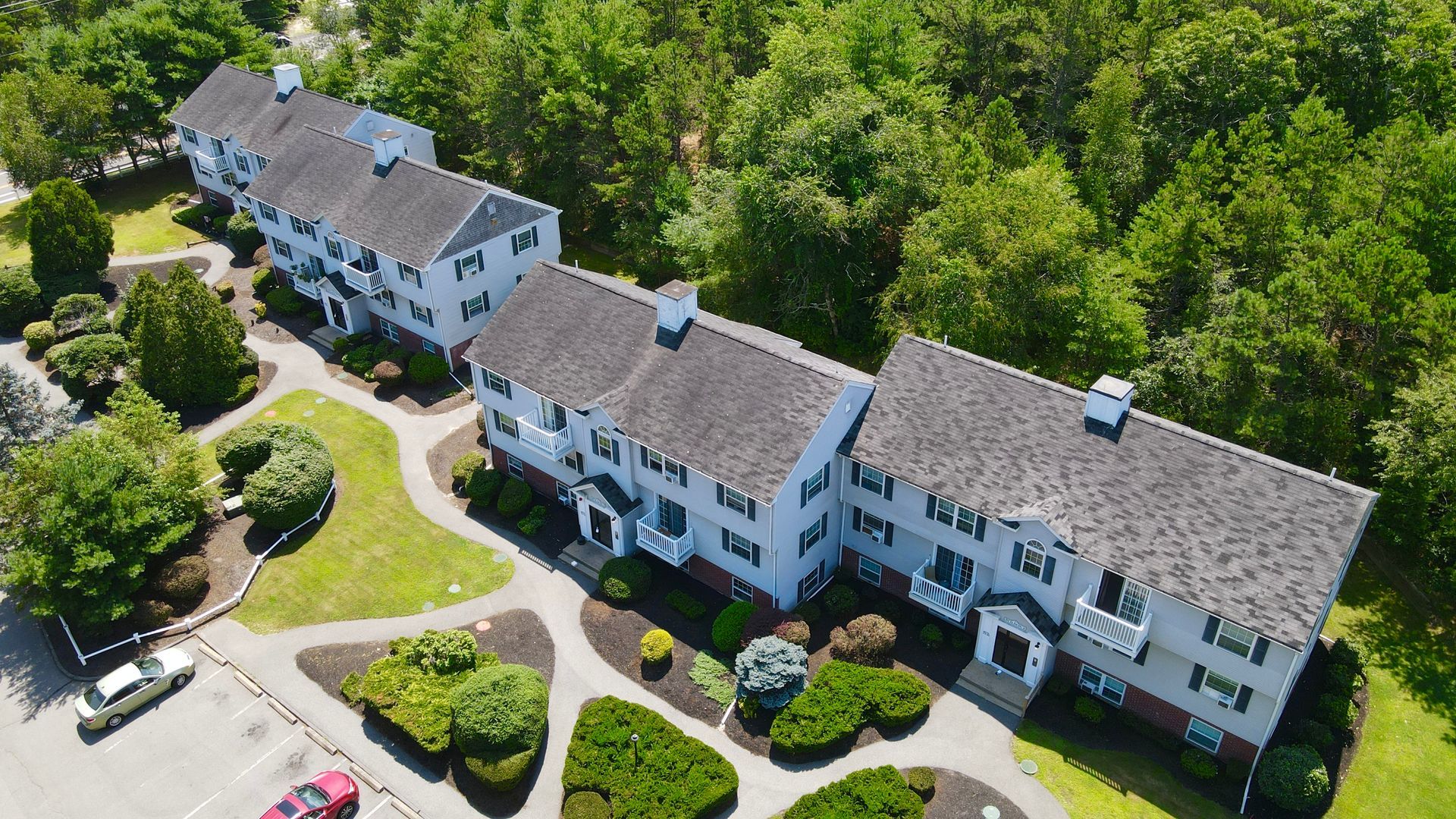 An aerial view of a row of houses surrounded by trees