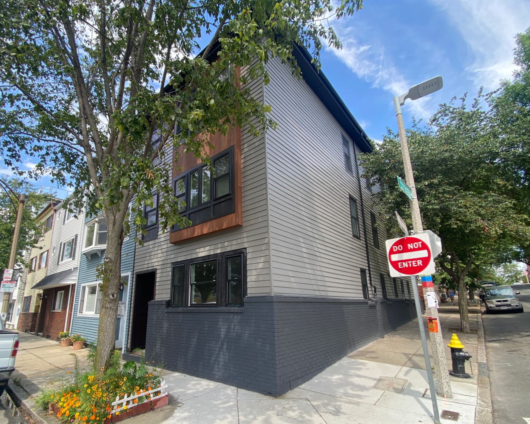 A building with a stop sign on the side of it is on the corner of a street.