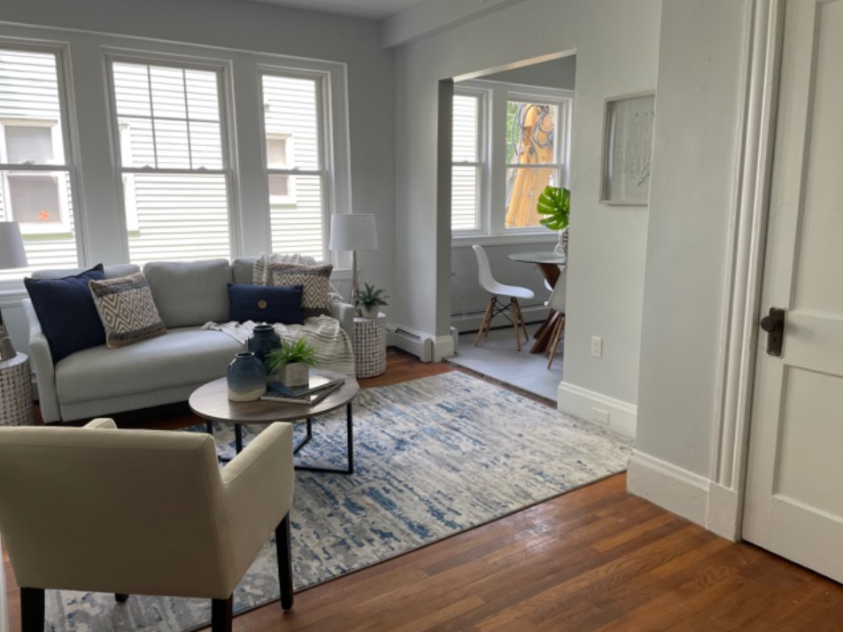 A living room with a couch , chair , table and rug.