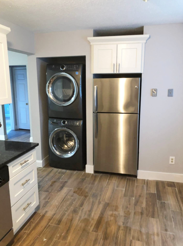 A kitchen with a washer and dryer stacked on top of each other