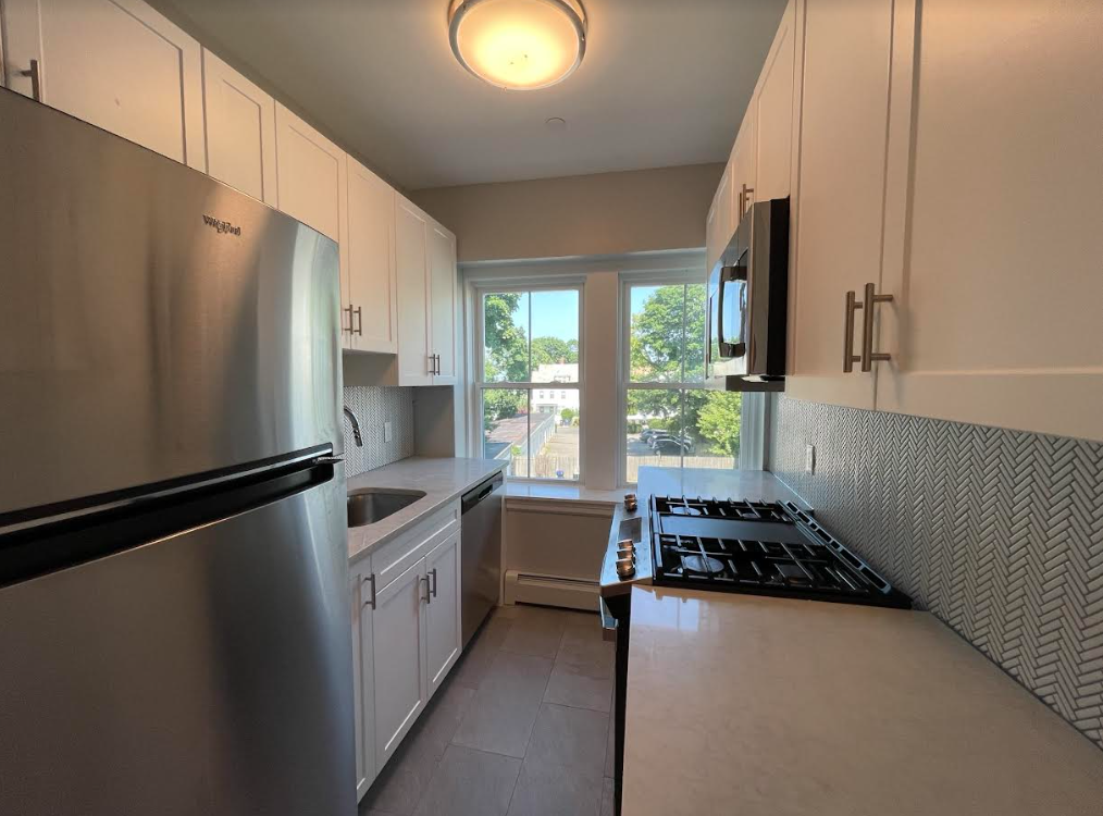 A kitchen with stainless steel appliances and white cabinets