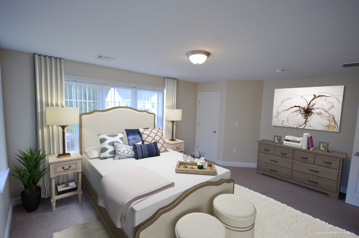 A bedroom with a large bed , dresser , nightstands and a window.