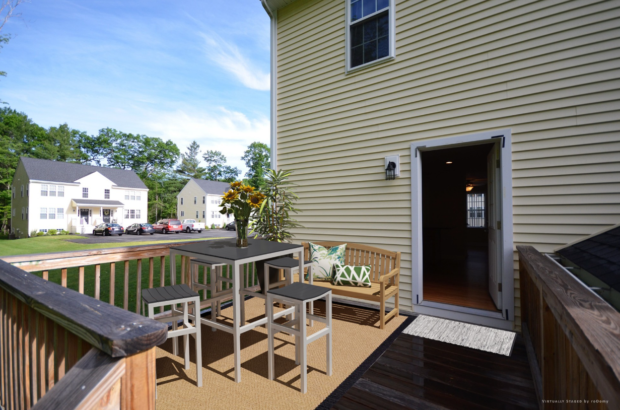 A wooden deck with a table and chairs on it
