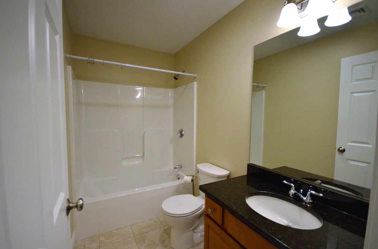 A bathroom with a toilet , sink and bathtub