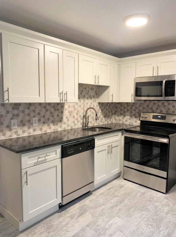 A kitchen with stainless steel appliances and white cabinets