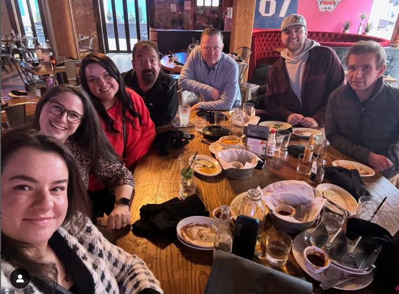 A group of people are sitting around a table in a restaurant.
