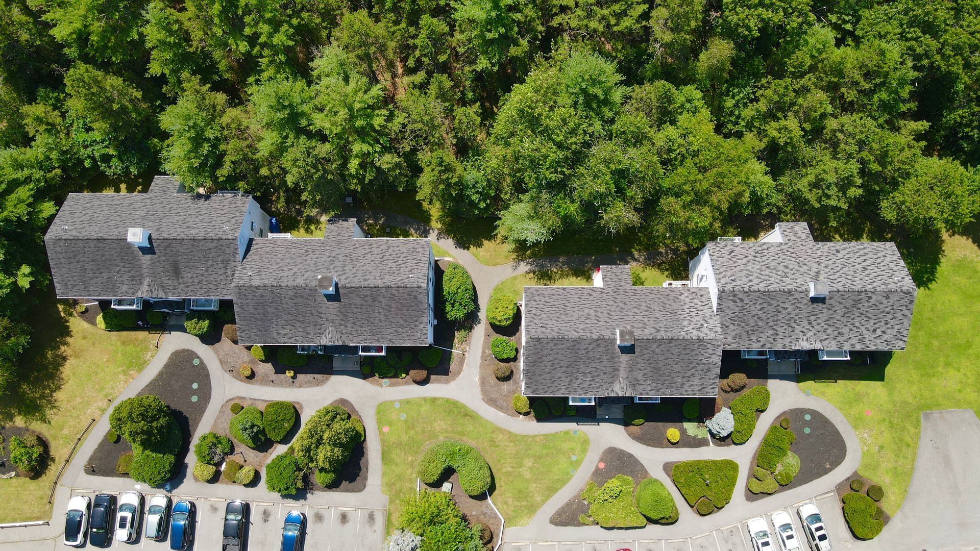 An aerial view of a row of houses surrounded by trees