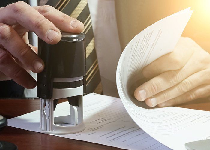 Law Office — Lawyer Stamping Confidential Documents Of Clients In Rockville, MD