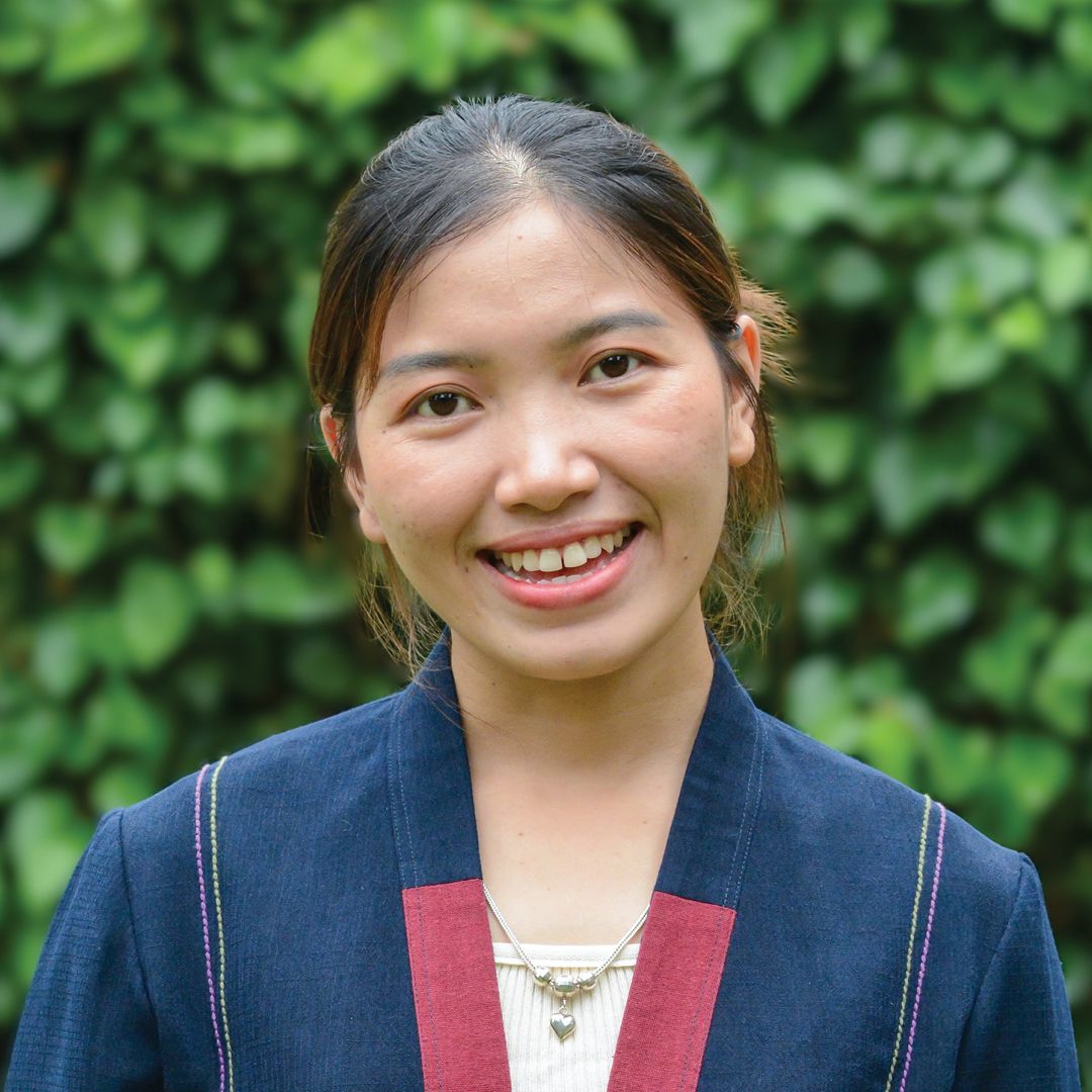 A young woman in a white shirt is smiling for the camera.