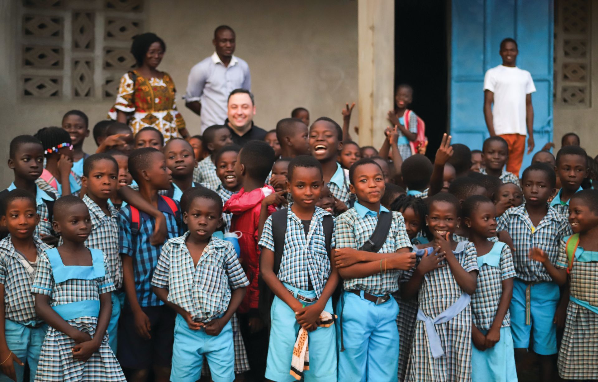 A group of children are posing for a picture in front of a building