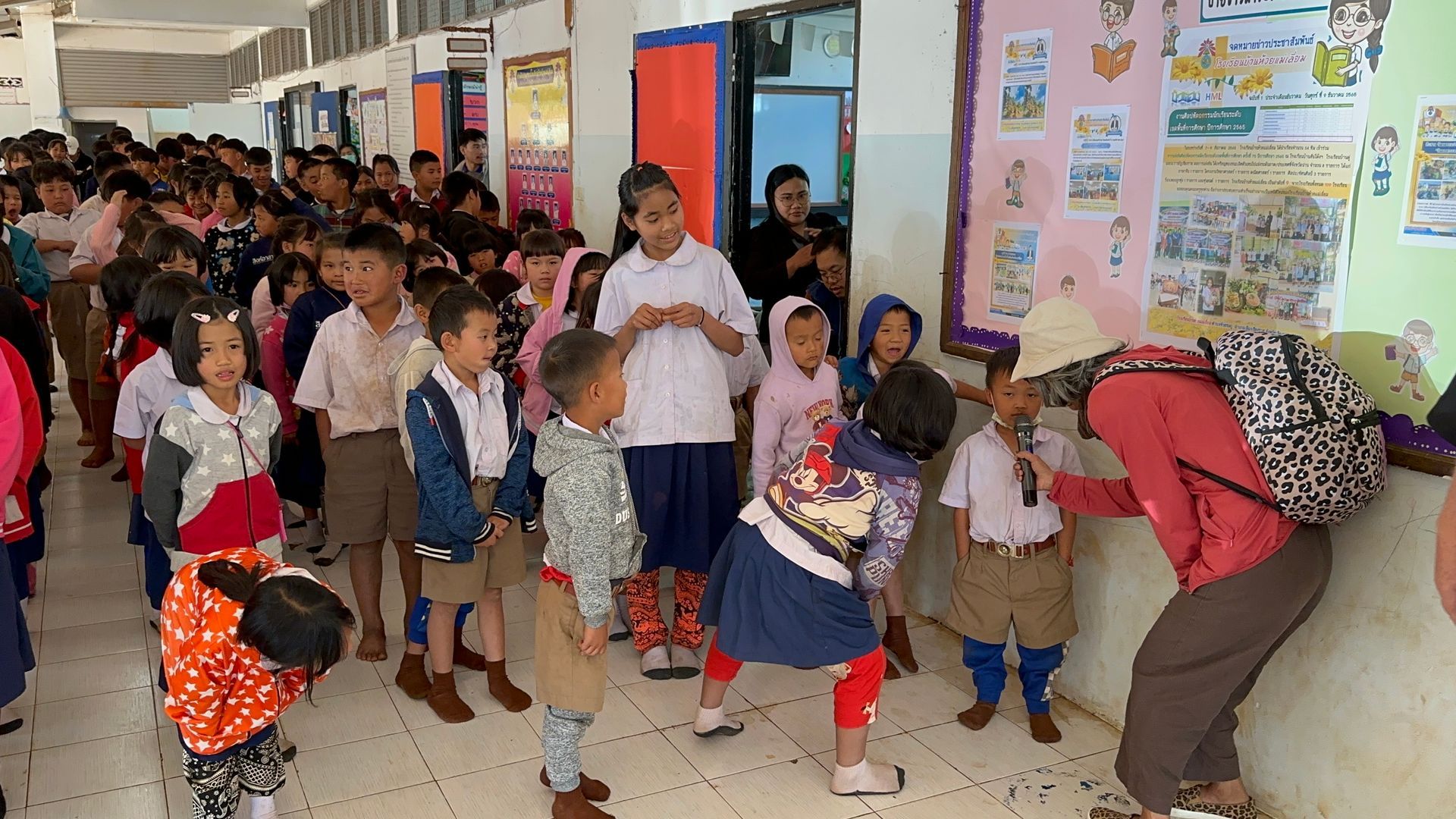 A large group of children are standing in a hallway.