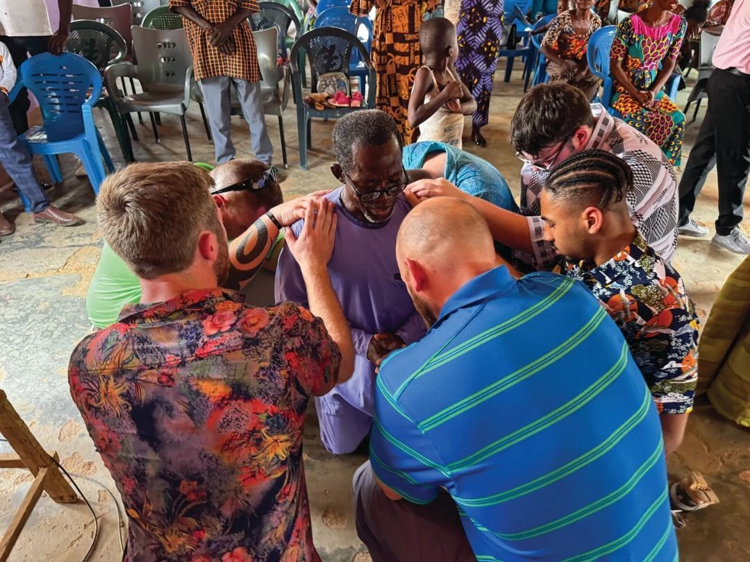 A group of people are sitting in a circle on the floor.