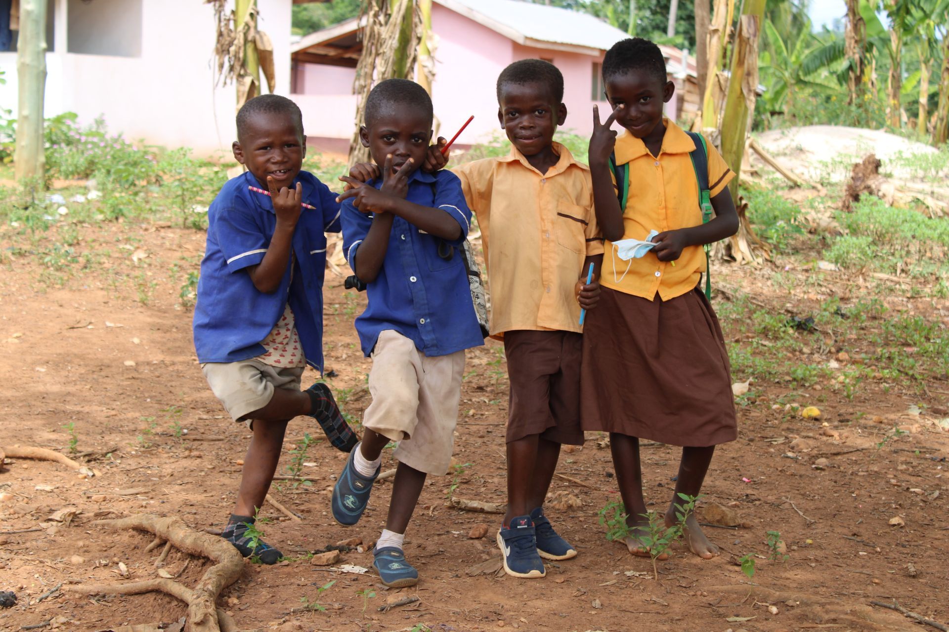 A group of children are posing for a picture in a dirt field