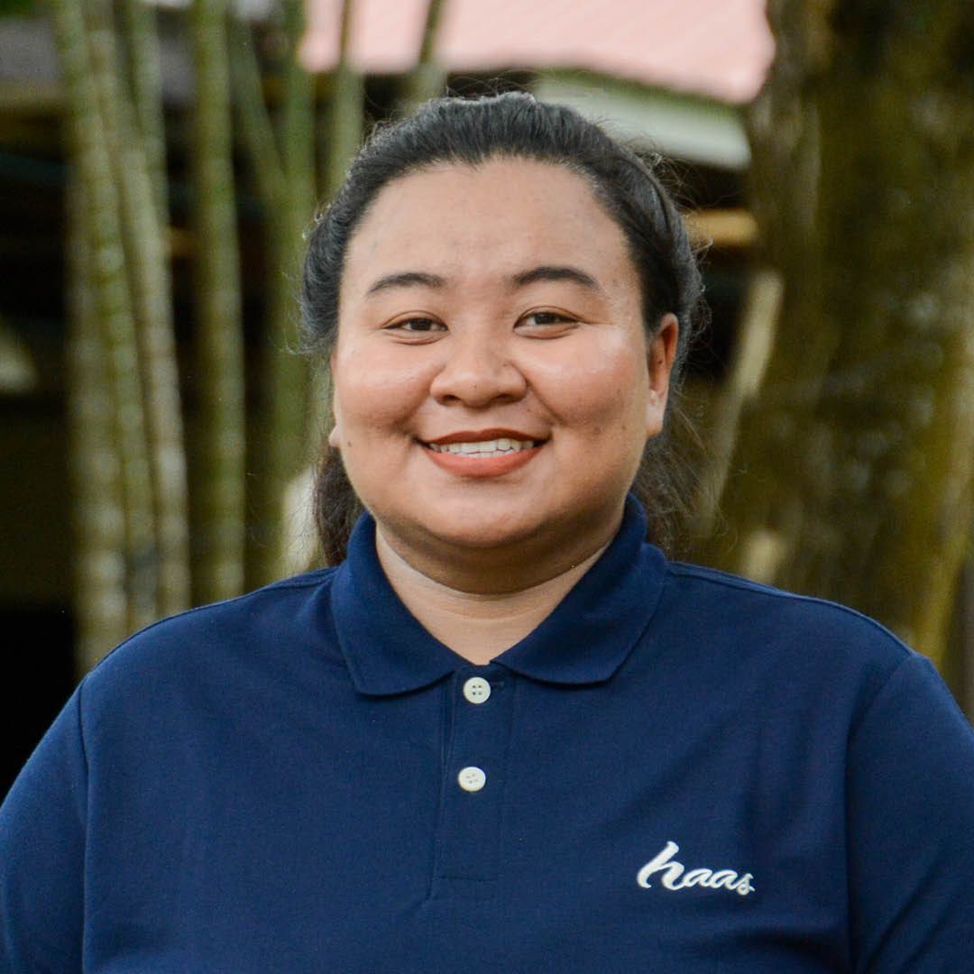 A woman wearing a blue polo shirt is smiling for the camera.