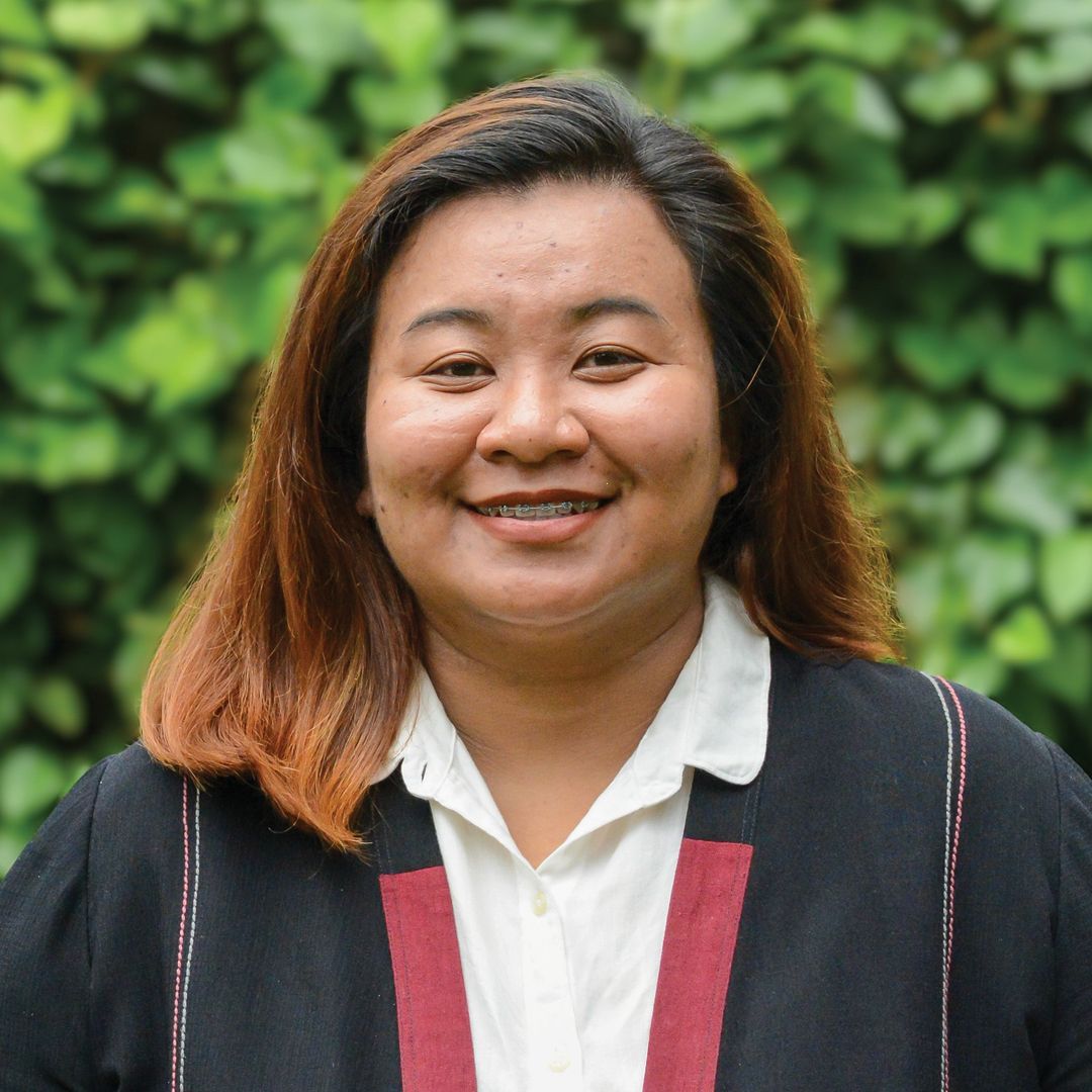 A woman wearing a blue polo shirt is smiling for the camera.