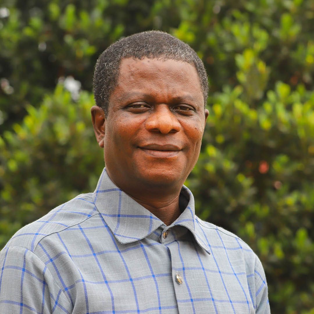 A man in a plaid shirt is smiling for the camera.