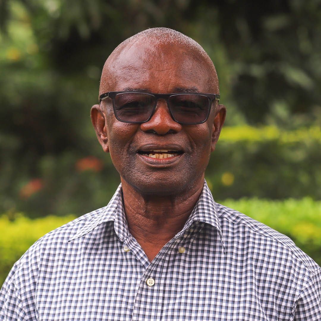 A man wearing sunglasses and a plaid shirt is smiling for the camera.