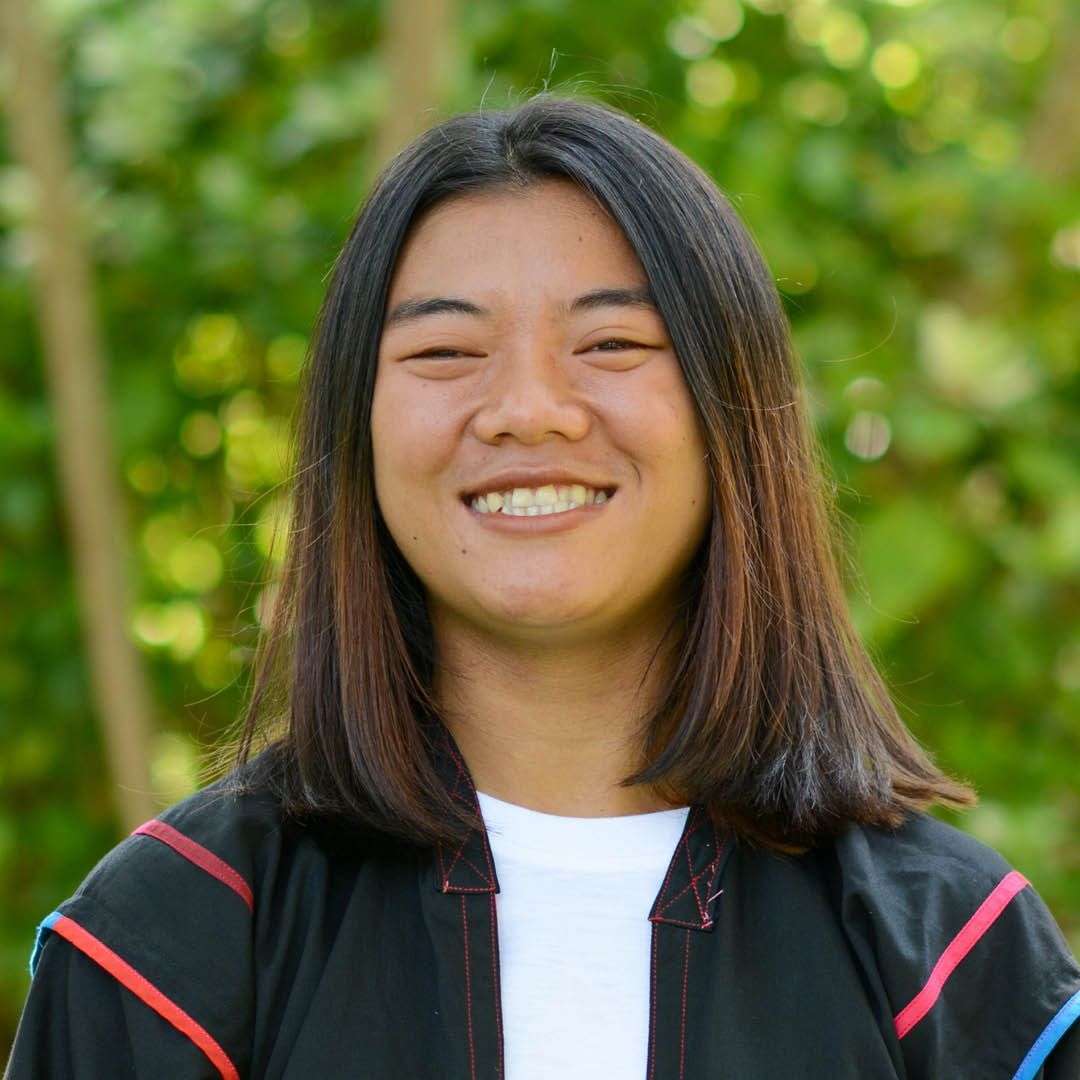 A young woman with long hair is smiling for the camera.