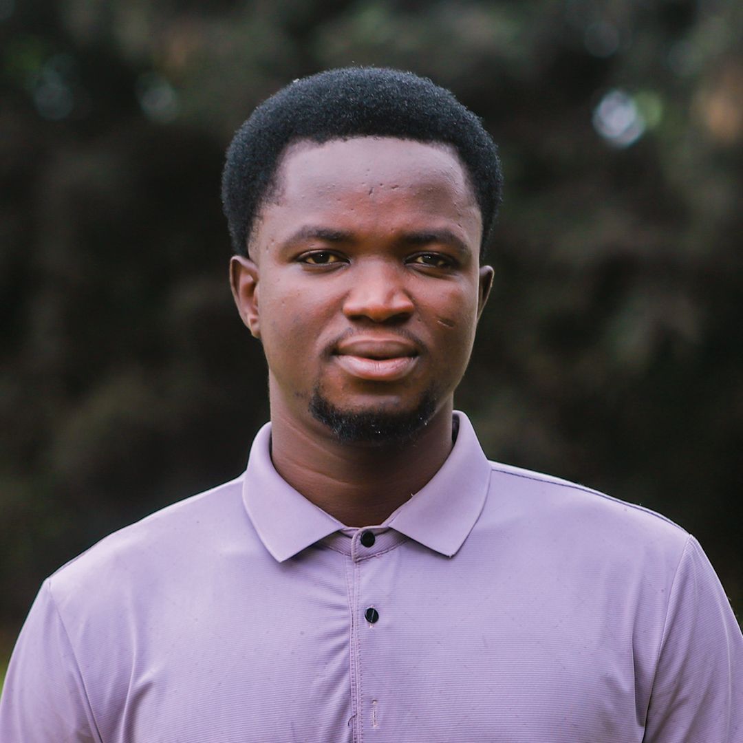 A man wearing a purple and orange shirt is smiling for the camera.