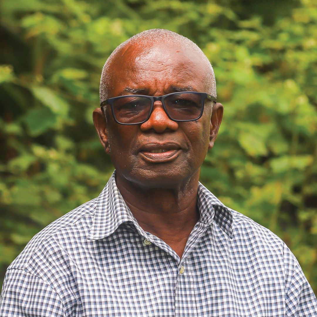 A man wearing sunglasses and a plaid shirt is smiling for the camera.